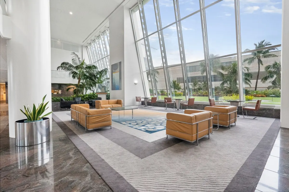 Spacious lobby with seating, large windows and indoor plants